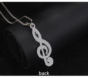 Detail view showing the textured back of a stainless steel treble clef music pendant