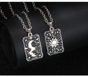 Détail macro des pendentifs Tarot Lune et Soleil sur chaîne avec gravures en émail noir