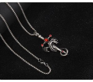 Détail du pendentif épée dragon gothique avec pierres rouges sur une chaîne à billes