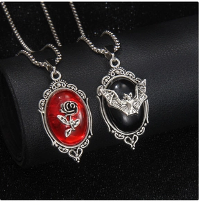 Detailed macro view of Gothic stainless steel necklaces with red rose and black bat cameos