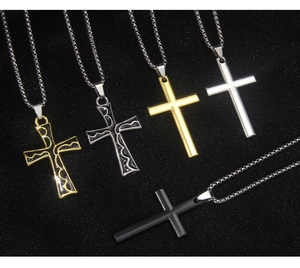 Detail von fünf Hip-Hop Kreuzanhängern in Gold, Silber und Schwarz an Kugelkettchen