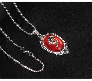 Macro detail of Gothic stainless steel necklace with red rose relief and oval gemstone