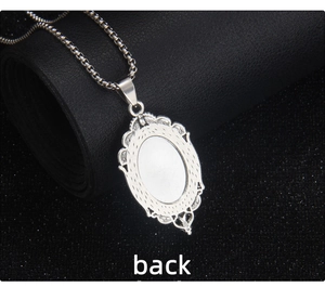Detailed back view of a gothic oval stainless steel pendant on a black leather background
