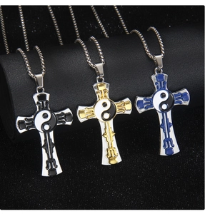 Vue détaillée des pendentifs croix Tai Chi en noir, or et bleu avec chaîne en acier