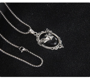 Macro detail of Gothic oval bat pendant necklace with black gemstone and silver chain