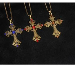 Nahaufnahme von Vintage Kreuzketten mit bunten Edelsteinen auf Gold-Edelstahlkette