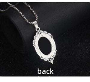 Macro detail of gothic oval pendant back featuring polished black inlay and metal filigree
