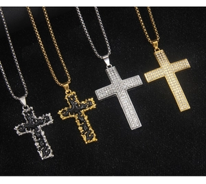 Detailansicht von Gold- und Silberkreuzanhängern mit Strass und schwarzen Emaille-Texturen