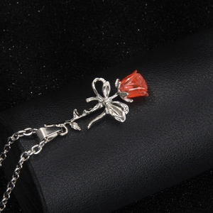 Collier minimaliste en acier inoxydable avec pendentif rose 3D sur un fond noir élégant