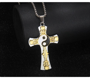 Détail macro du pendentif croix argent et or avec symbole yin yang sur chaîne à billes