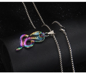 Macro detail of iridescent cobra snake pendant on silver box chain necklace