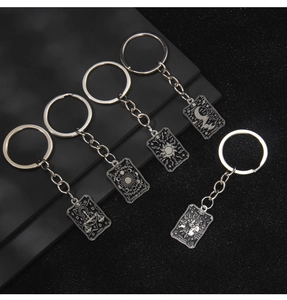 Lot de cinq porte-clés tarot en métal argenté avec motifs de la Justice et du Soleil