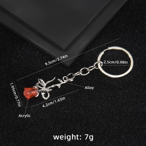 Chic red acrylic rose and silver butterfly keychain on elegant black textured background