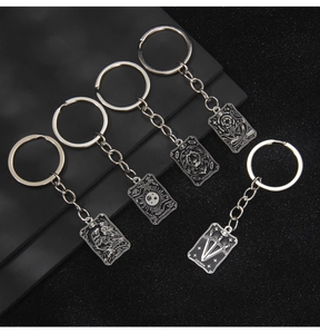 Détails de cinq porte-clés en métal sur le thème des cartes de tarot avec motifs gravés