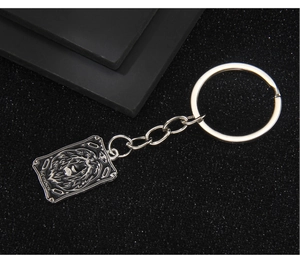Détail du porte-clés tarot en métal argenté avec relief lion et finition émail noir