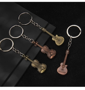Macro detail of vintage bronze musical instrument keychains on a textured background