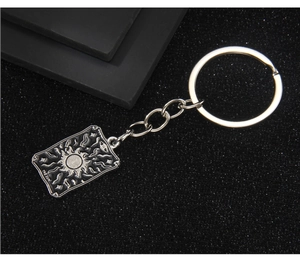 Détail du porte-clés Tarot avec gravure The Sun et finition en émail noir brillant