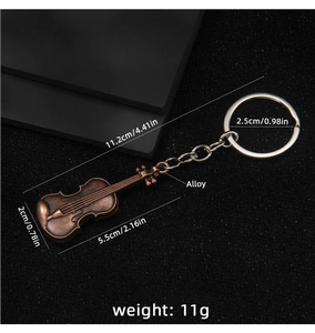 Macro view of vintage bronze violin keychain with detailed alloy texture and dimensions
