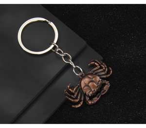 Macro detail of bronze crab keychain featuring realistic shell textures and vintage finish