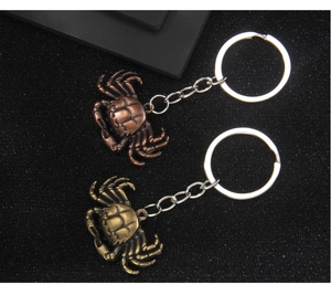 Detailed top view of retro metal crab keychains in copper and bronze antique finishes