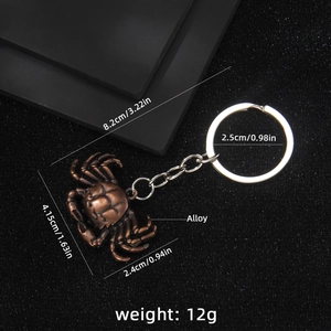 Vintage bronze crab keychain in alloy with detailed measurements on a black background