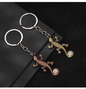 Détails des porte-clés lézard en bronze et laiton avec strass et textures d'écailles