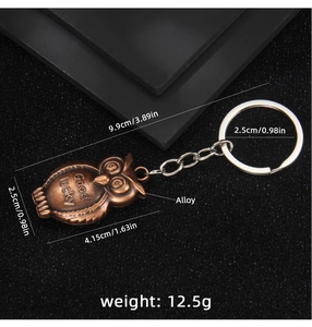 Close-up of vintage bronze owl keychain showing dimensions and Good Lucky engraving