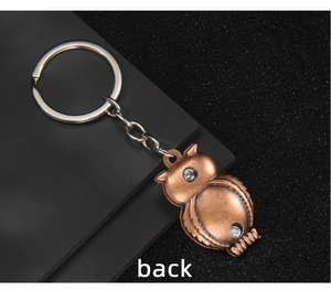 Detailed back view of a vintage bronze owl alloy keychain with a metallic silver split ring