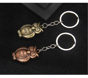 Detailed view of owl keychains in bronze and copper with lucky engraving and textures