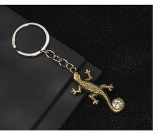 Détail macro du porte-clés lézard en bronze avec cristal et textures d'écailles