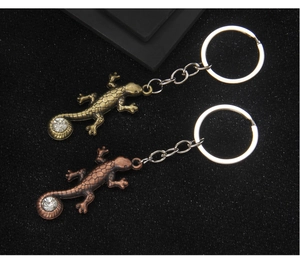 Détail du porte-clés lézard en métal avec textures d'écailles et faux diamants