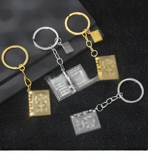 Gros plan de porte-clés livre de croix vintage en or et argent sur surface noire