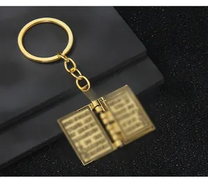 Vue détaillée d'un porte-clés bible vintage doré avec de petites pages de texte