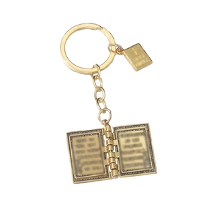Porte-clés livre de la Bible dorée vintage avec pendentif croix sur fond blanc neutre