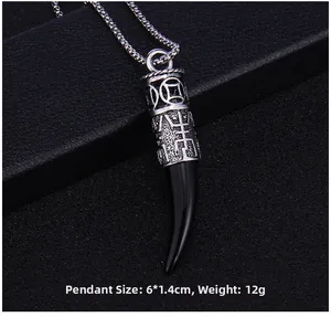 Macro view of vintage wolf tooth pendant with hollow metal details and black horn resin