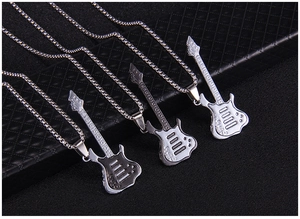 Vue détaillée de trois colliers pendentifs guitare en argent, noir et fini mat