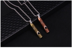 Vue détaillée des pendentifs sifflets vintage en finitions cuivre et bronze