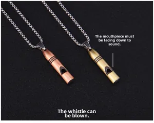 Vue détaillée des pendentifs sifflets en laiton et cuivre vintage sur fond noir texturé