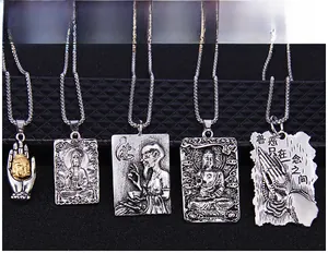 Close-up of vintage silver Buddhist pendants with Buddha and Guanyin embossed motifs