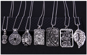 Detailed relief of vintage silver Chinese zodiac pendants on black textured background
