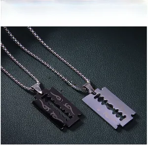 Détail de pendentifs lame de flamme noir et argent avec gravures tribales sur chaînes