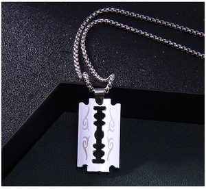 Gros plan du pendentif lame de flamme argentée avec gravure sur chaîne box