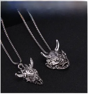 Detail of punk style horned skull and demon mask pendants with silver finish