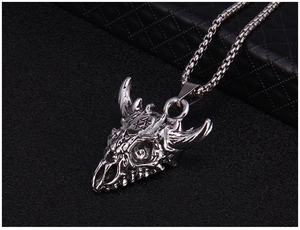 Close-up of vintage silver bull skull pendant with hexagram detail on a black background