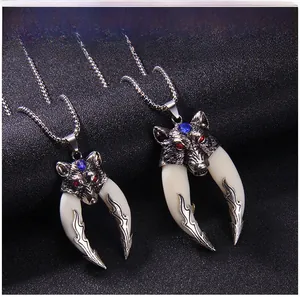 Macro detail of retro wolf head pendants with red blue stones and white tusks