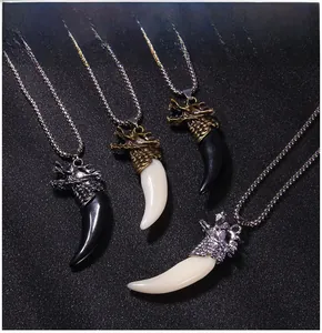 Macro detail of retro dragon head pendants with white and black faux fangs and bead chains