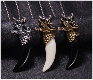 Three retro dragon head pendants with faux wolf tusks in silver and bronze finish