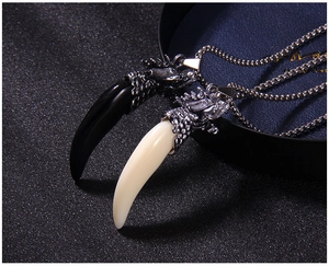 Detailed close-up of retro wolf tooth pendants with dragon heads on stainless steel necklaces