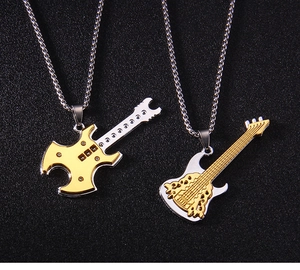 Détail de pendentifs guitare or et argent au design instrument de musique punk rock