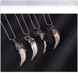 Close-up of four assorted animal totem fang pendants with detailed metal carvings and bead chains